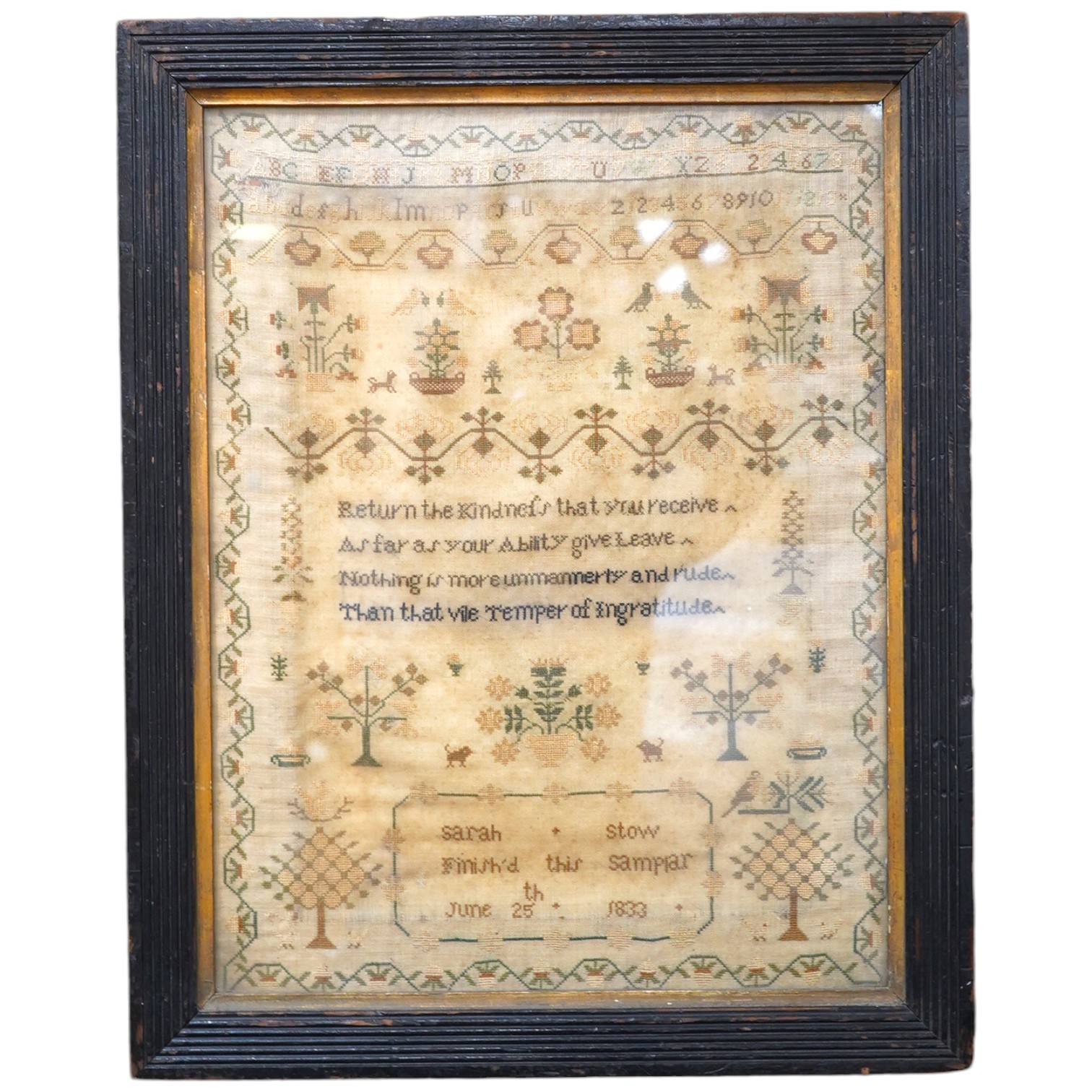 A spot motif and verse sampler, by Sarah Stow dated 1833, worked in multi-coloured silks, with a vineous border, a row of alphabet letters with a wide panel of spot motifs of birds and flowers above an embroidered verse